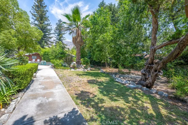 an aerial view of a house with swimming pool and large trees