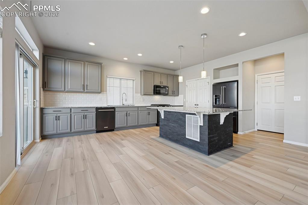 6640 Backcountry Loop Colorado Springs, CO 80927 - Photo 15 of 49 a large kitchen with stainless steel appliances kitchen island a large counter top and a sink