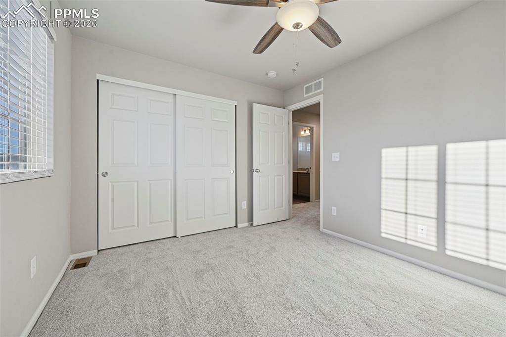6640 Backcountry Loop Colorado Springs, CO 80927 - Photo 34 of 49 an empty room with windows and chandelier fan