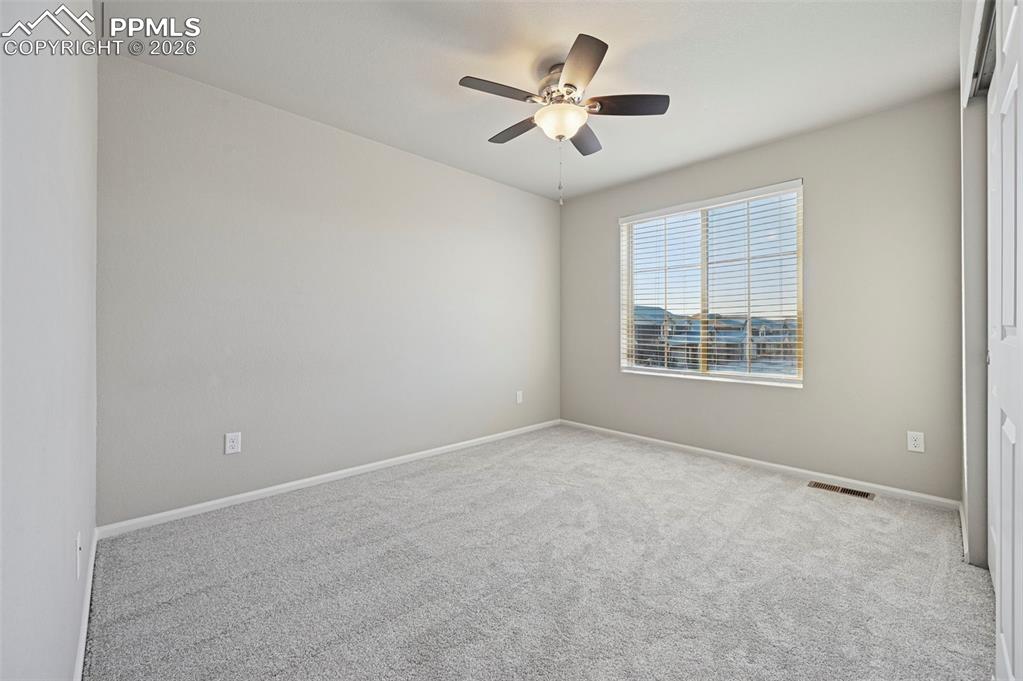 6640 Backcountry Loop Colorado Springs, CO 80927 - Photo 35 of 49 an empty room with windows and ceiling fan