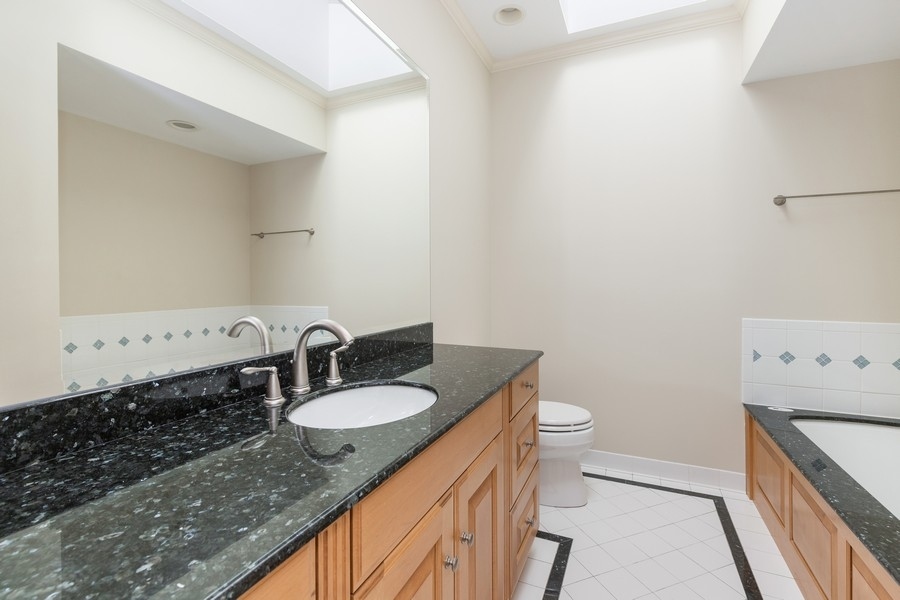 55 Stone Gate Road Lake Forest, IL 60045 - Photo 36 of 62 a bathroom with a granite countertop sink a toilet and a mirror