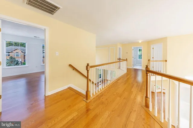 a view of a bedroom with wooden floor and windows
