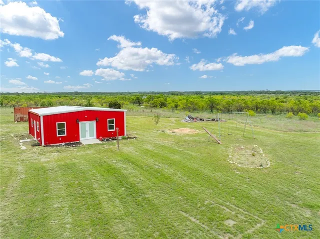 a view of swimming pool with lawn chairs and plants