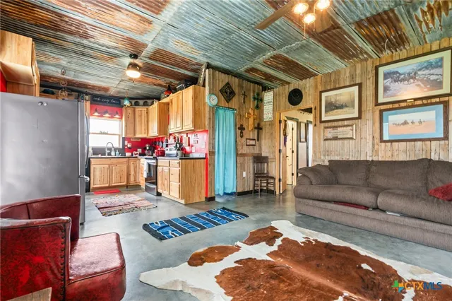 a open kitchen with stainless steel appliances granite countertop a refrigerator a sink and a stove