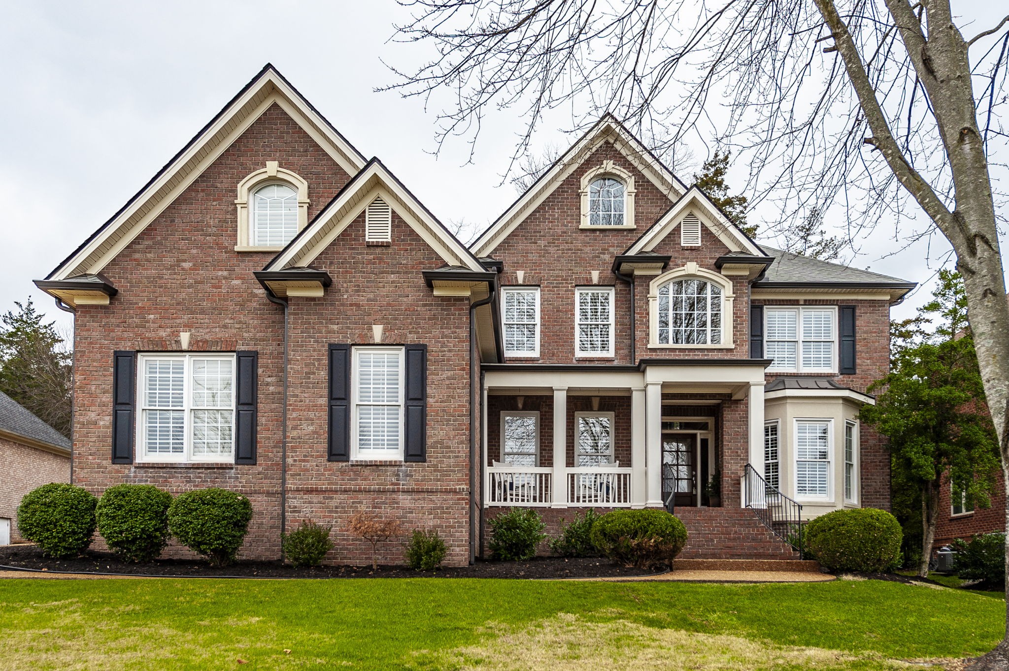 a front view of a house with a yard and trees