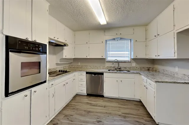 a kitchen with granite countertop white cabinets and white appliances