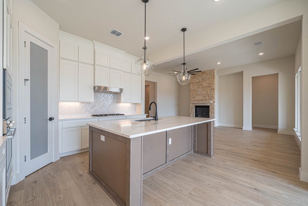 2013 Toscano Way Kerrville, TX 78028 - Photo 8 of 17 a kitchen with kitchen island a sink stainless steel appliances and a chandelier