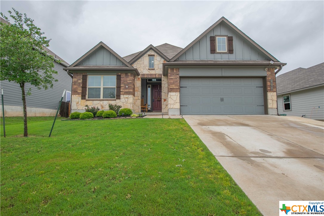 a front view of a house with a yard and trees