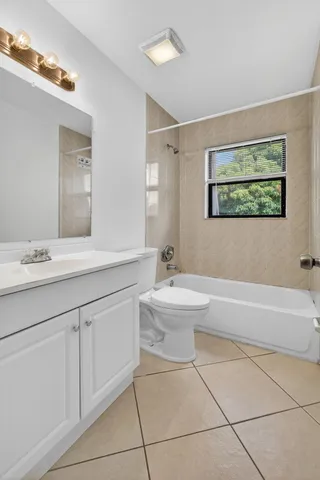 a bathroom with a toilet a sink a mirror and bathtub