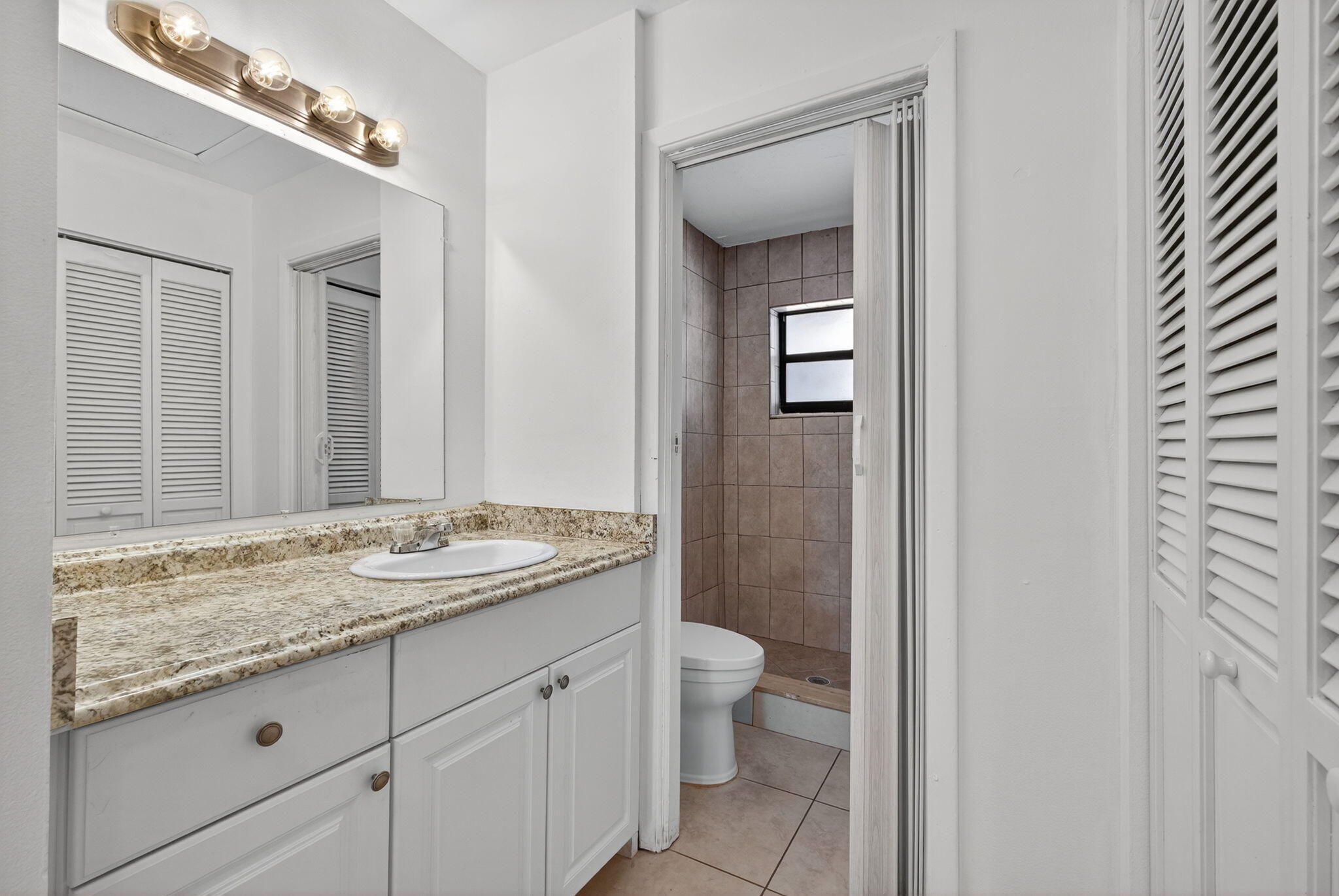 1580 Montauk Drive, Unit 1582 Wellington, FL 33414 - Photo 21 of 28 a bathroom with a granite countertop sink and a mirror