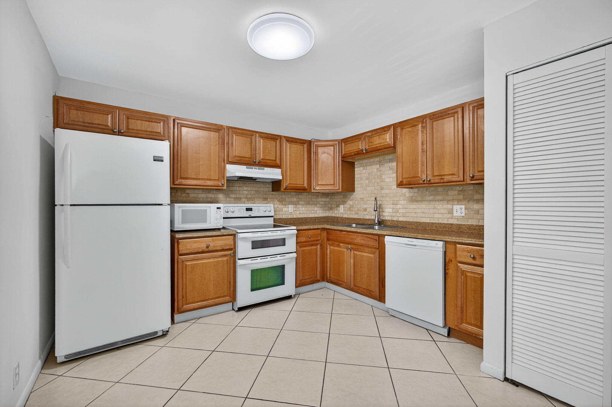 1580 Montauk Drive, Unit 1582 Wellington, FL 33414 - Photo 10 of 28 a kitchen with stainless steel appliances granite countertop a refrigerator sink and stove