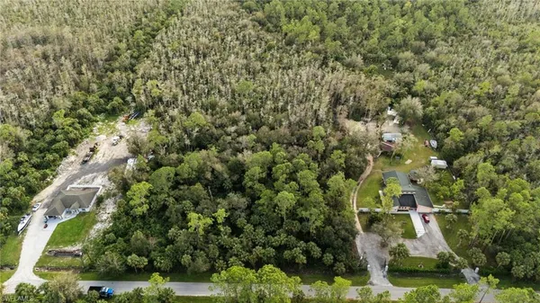 an aerial view of a residential houses with yard