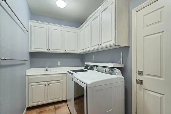 a utility room with sink dryer and washer