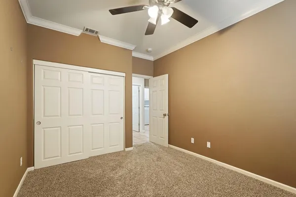 an empty room with chandelier fan