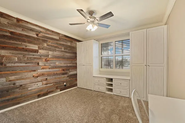 a view of an empty room with a ceiling fan and a window