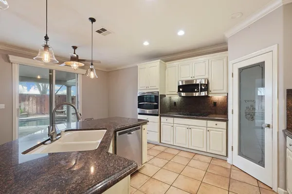 a kitchen with kitchen island a counter top space appliances and cabinets