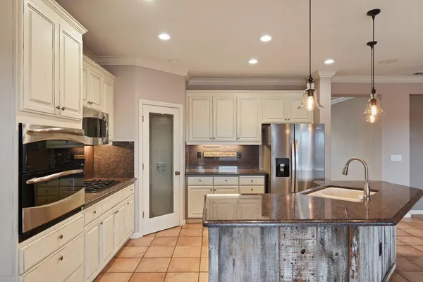 a kitchen with kitchen island granite countertop a sink and stainless steel appliances