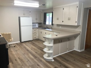 1615 Pioneer Road Draper, UT 84020 - Photo 10 of 13 Kitchen featuring wood-finish flooring, white cabinetry, a built-in breakfast bar with open shelving, and a double basin sink