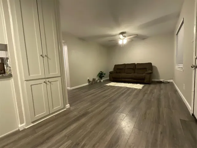 a room with wooden floor and ceiling fan