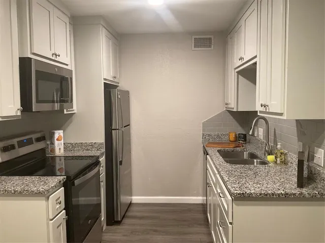 a kitchen with granite countertop stainless steel appliances and a counter space