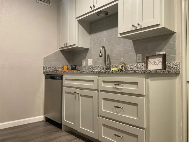 a kitchen with granite countertop white cabinets and white appliances