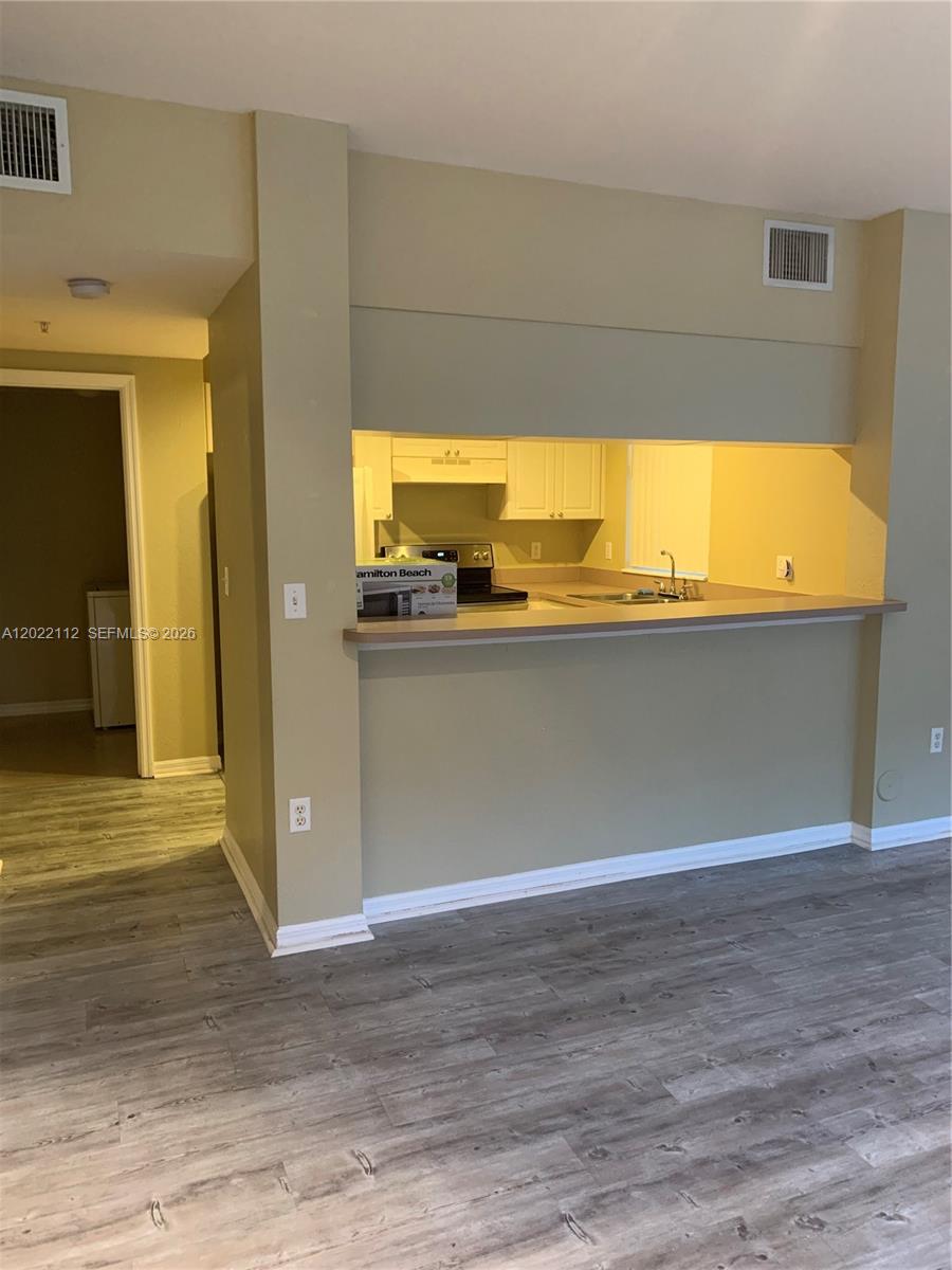 6572 West Sample Road, Unit 6572 Coral Springs, FL 33067 - Photo 4 of 17 a view of a room with wooden floor and a large window