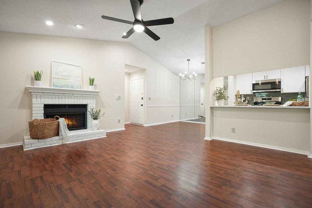 a view of a kitchen with a stove a kitchen island wooden floor and ceiling fan