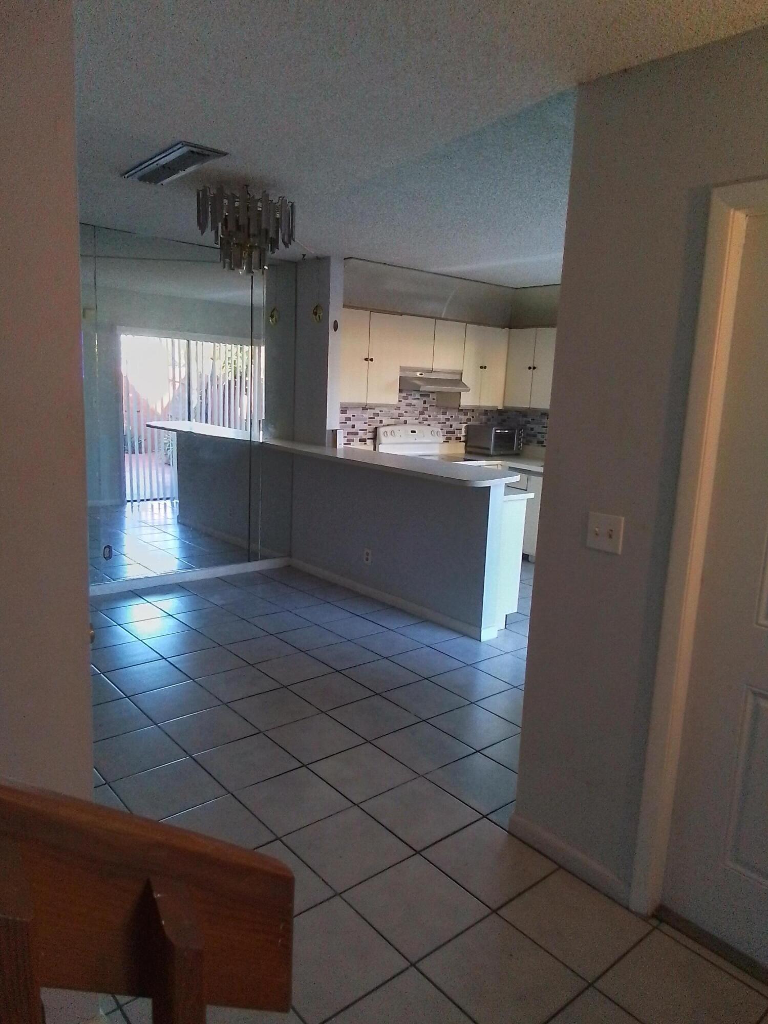1458 North Lawnwood Circle, Unit 23C Fort Pierce, FL 34950 - Photo 13 of 42 a kitchen with granite countertop white cabinets and window