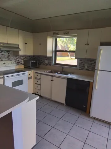 a kitchen with cabinets appliances and a stove