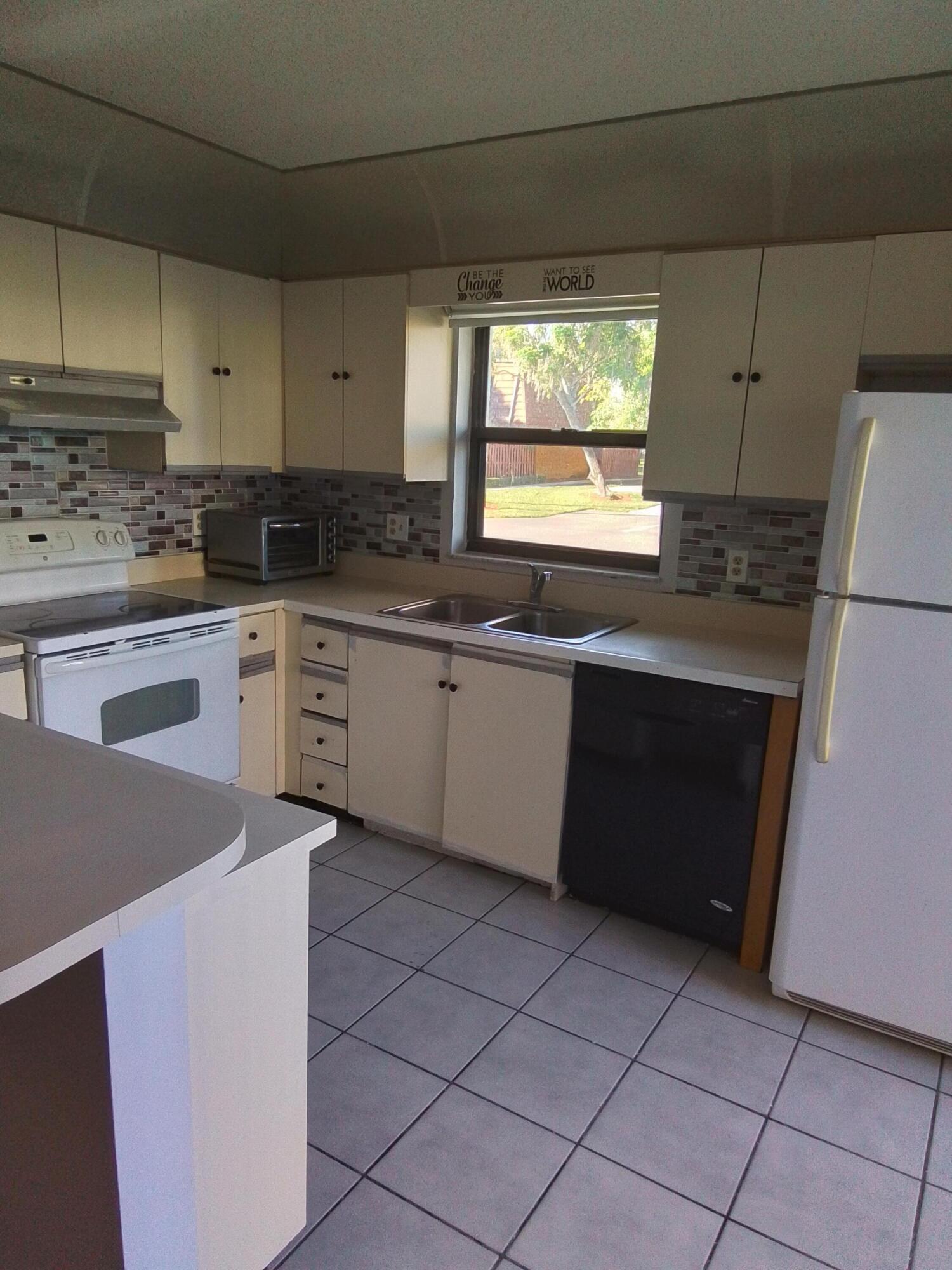 1458 North Lawnwood Circle, Unit 23C Fort Pierce, FL 34950 - Photo 15 of 42 a kitchen with a sink stove and cabinets