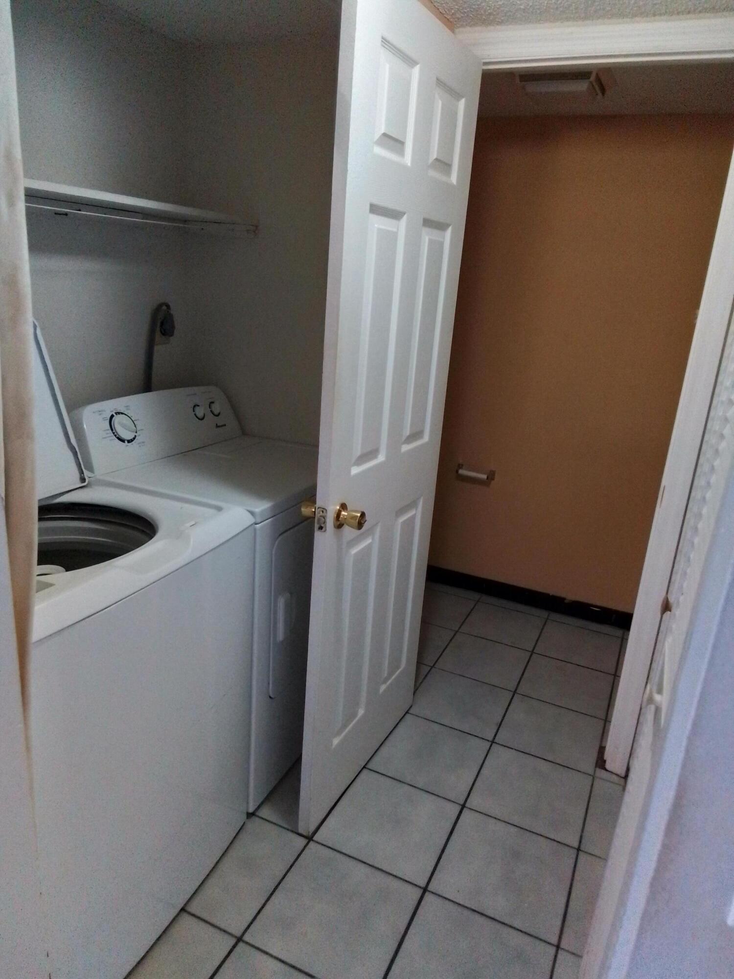 1458 North Lawnwood Circle, Unit 23C Fort Pierce, FL 34950 - Photo 23 of 42 a utility room with cabinets washer and dryer