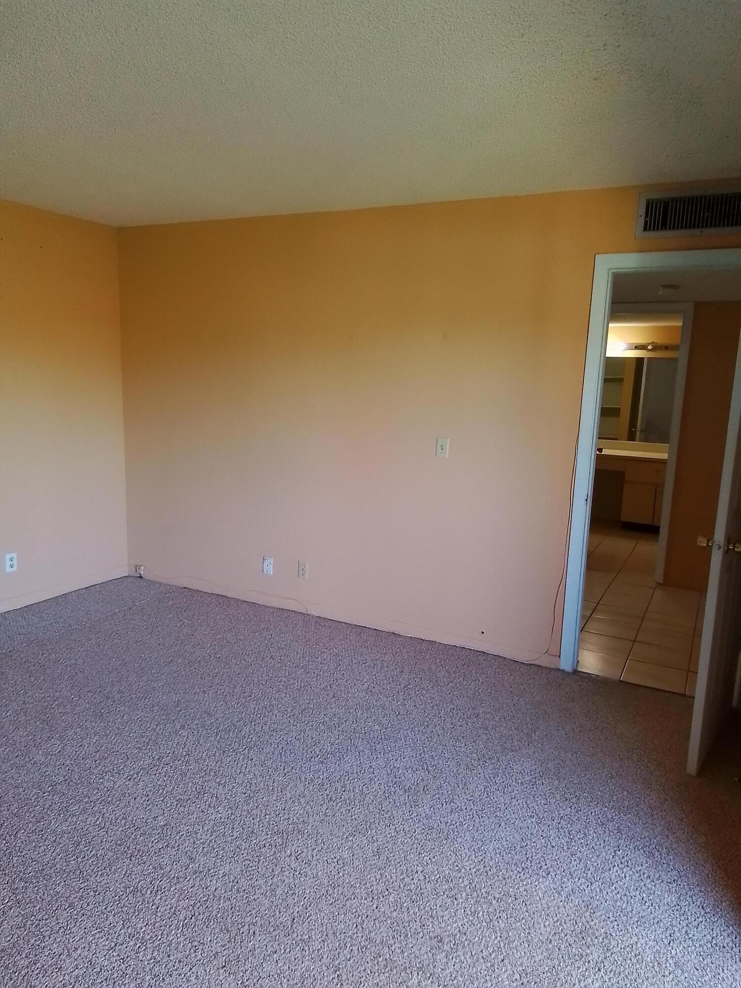 1458 North Lawnwood Circle, Unit 23C Fort Pierce, FL 34950 - Photo 31 of 42 a view of an empty room and wooden floor