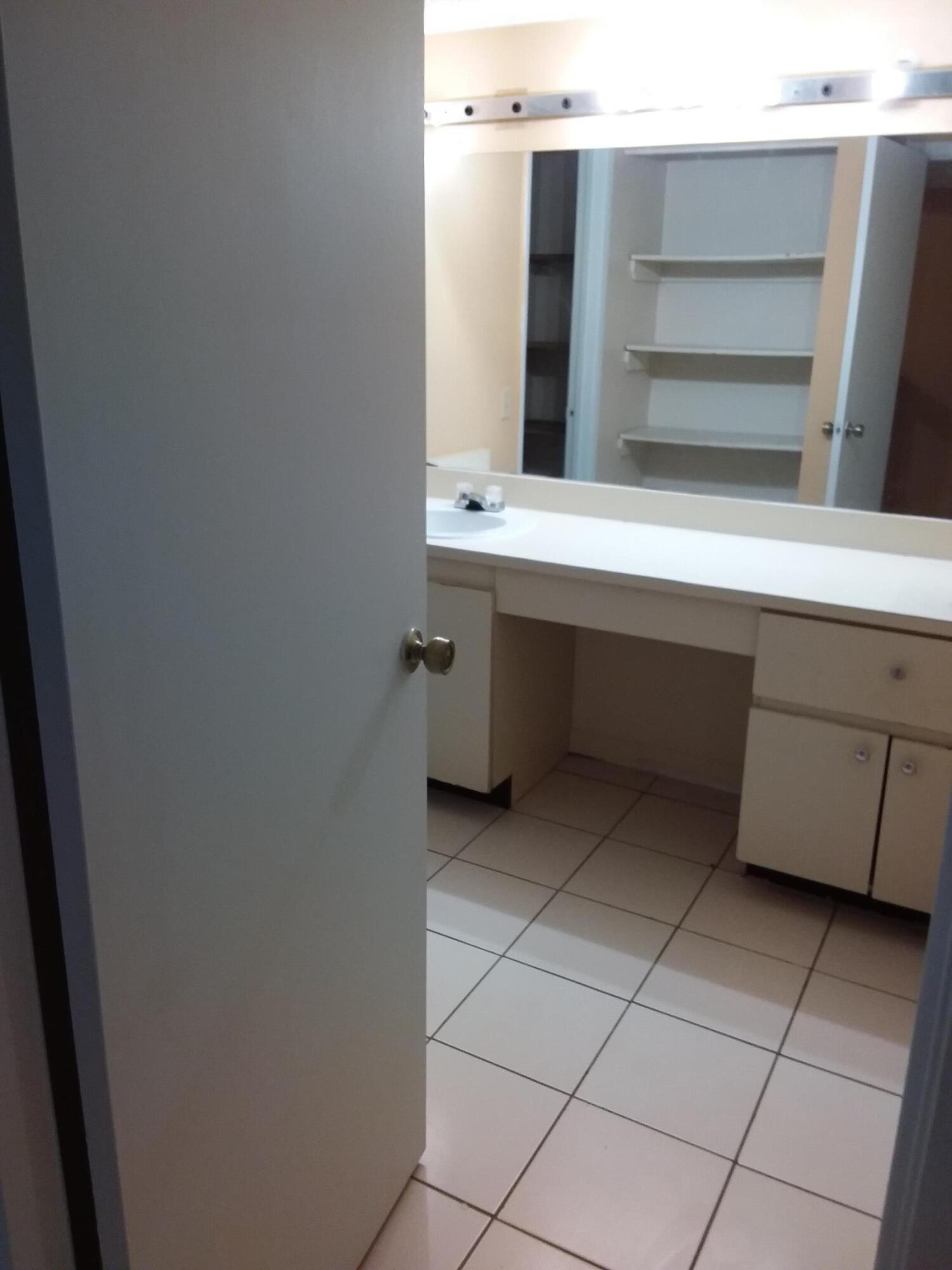 1458 North Lawnwood Circle, Unit 23C Fort Pierce, FL 34950 - Photo 34 of 42 a bathroom with a sink and a mirror