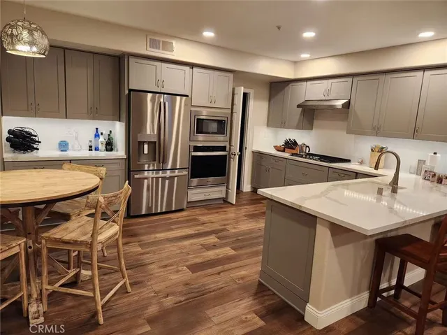 a kitchen with kitchen island granite countertop a sink stove and refrigerator