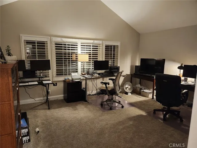 a view of a workspace with furniture and a window