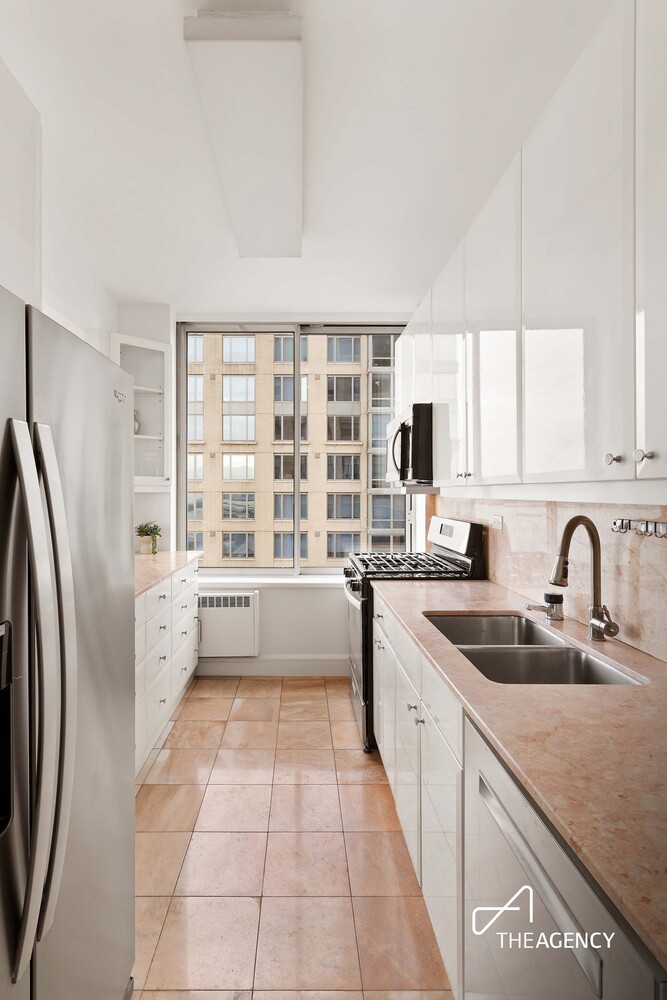 200 Riverside Boulevard, Unit 25C Manhattan, NY 10069 - Photo 11 of 17 a large white kitchen with a granite countertop sink