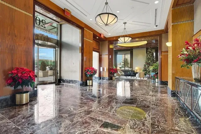 a large hall with stainless steel appliances wooden floor and living room view