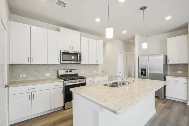 a view of a dining room with furniture a kitchen and chandelier
