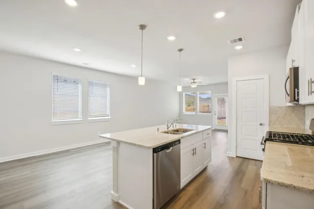 a kitchen with a sink a microwave a stove and refrigerator