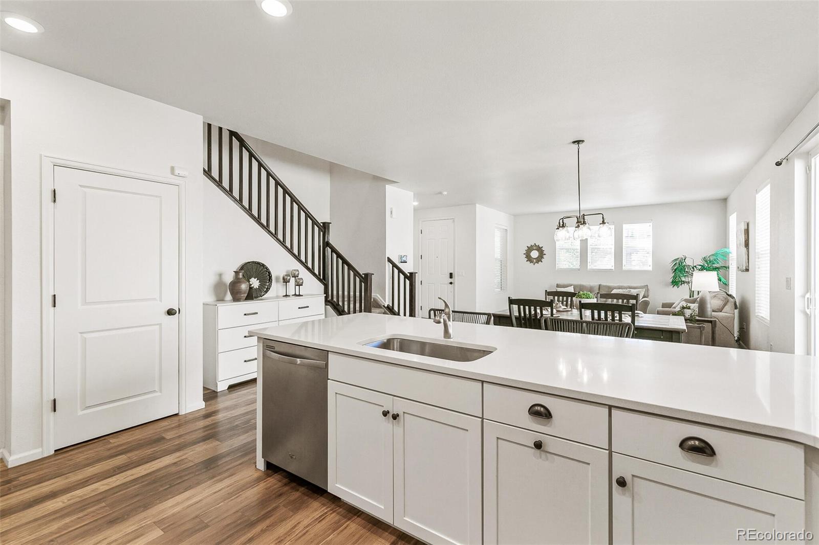 11159 East 25th Drive Aurora, CO 80010 - Photo 12 of 23 a spacious kitchen with a sink and dishwasher with white cabinets