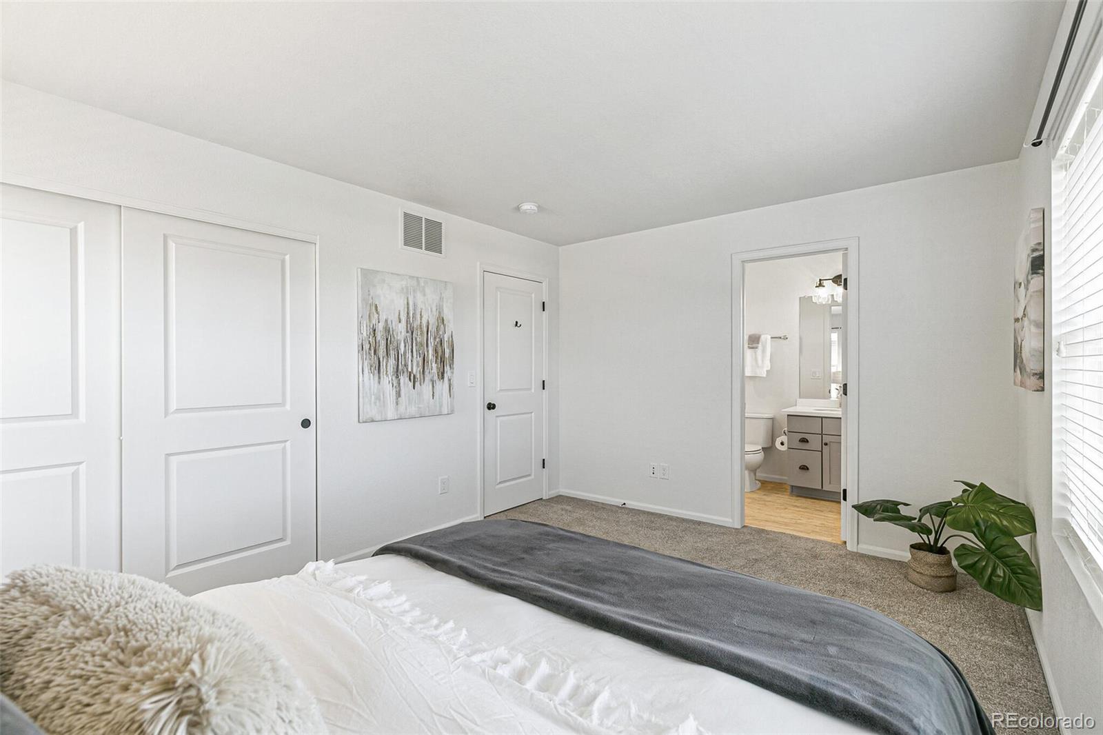 11159 East 25th Drive Aurora, CO 80010 - Photo 15 of 23 a bedroom with a bed and a painting on the wall