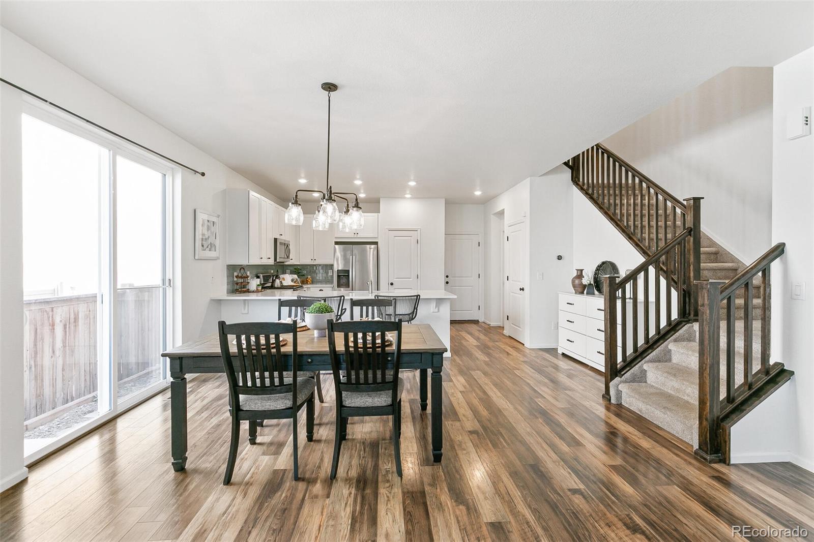 11159 East 25th Drive Aurora, CO 80010 - Photo 8 of 23 a view of a dining room with furniture window and wooden floor