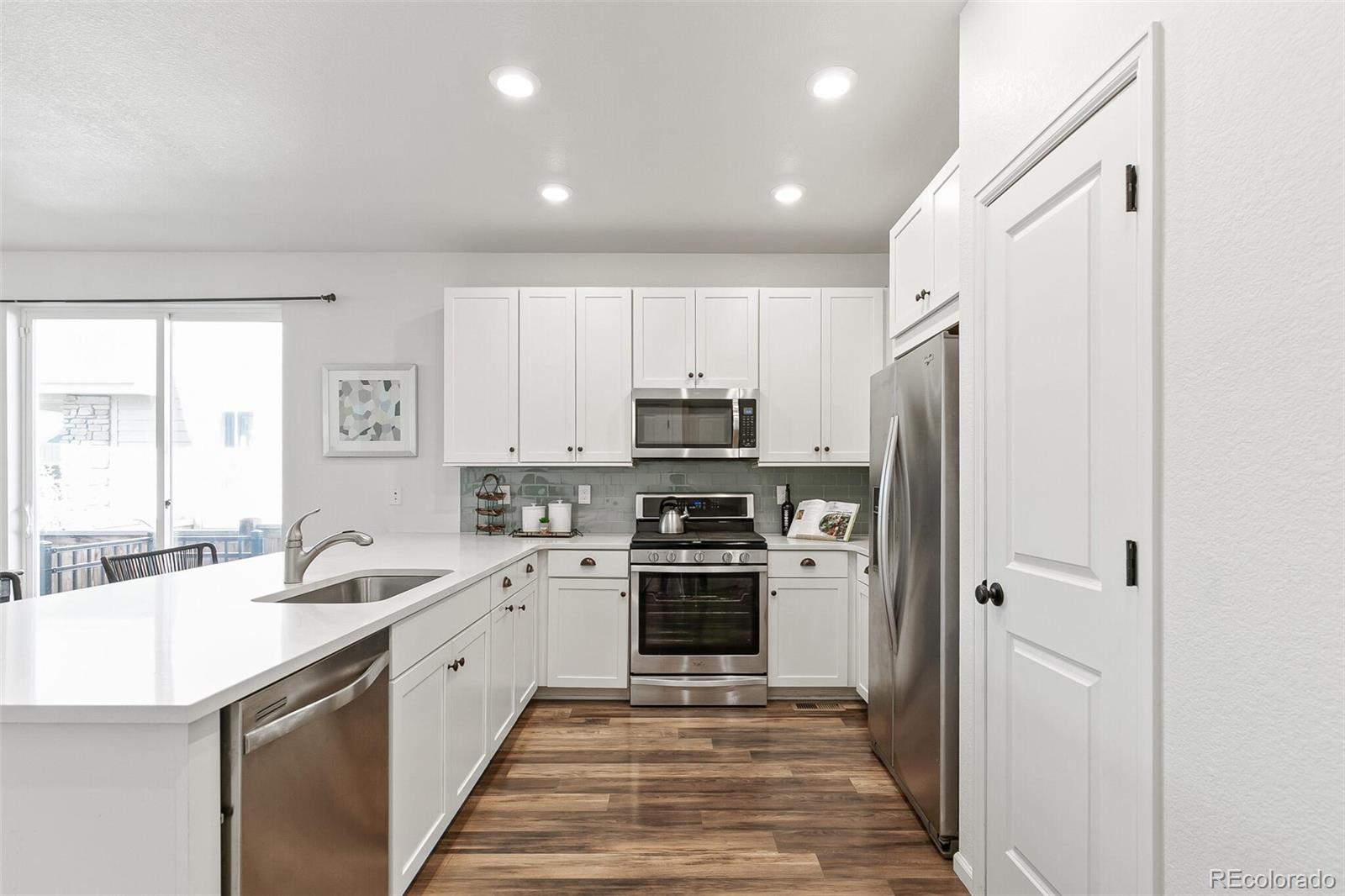 11159 East 25th Drive Aurora, CO 80010 - Photo 10 of 23 a kitchen with a sink cabinets stainless steel appliances and a window
