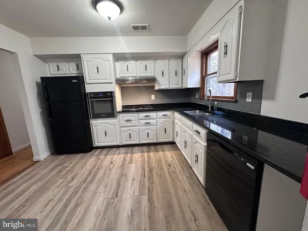 a kitchen with stainless steel appliances granite countertop a stove a sink dishwasher a refrigerator and a stove