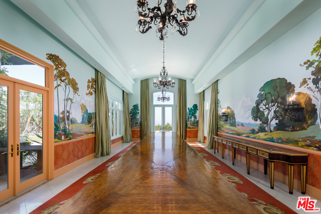 73 Beverly Park Lane Beverly Hills, CA 90210 - Photo 14 of 24 a view of a hallway with wooden floor and chandelier