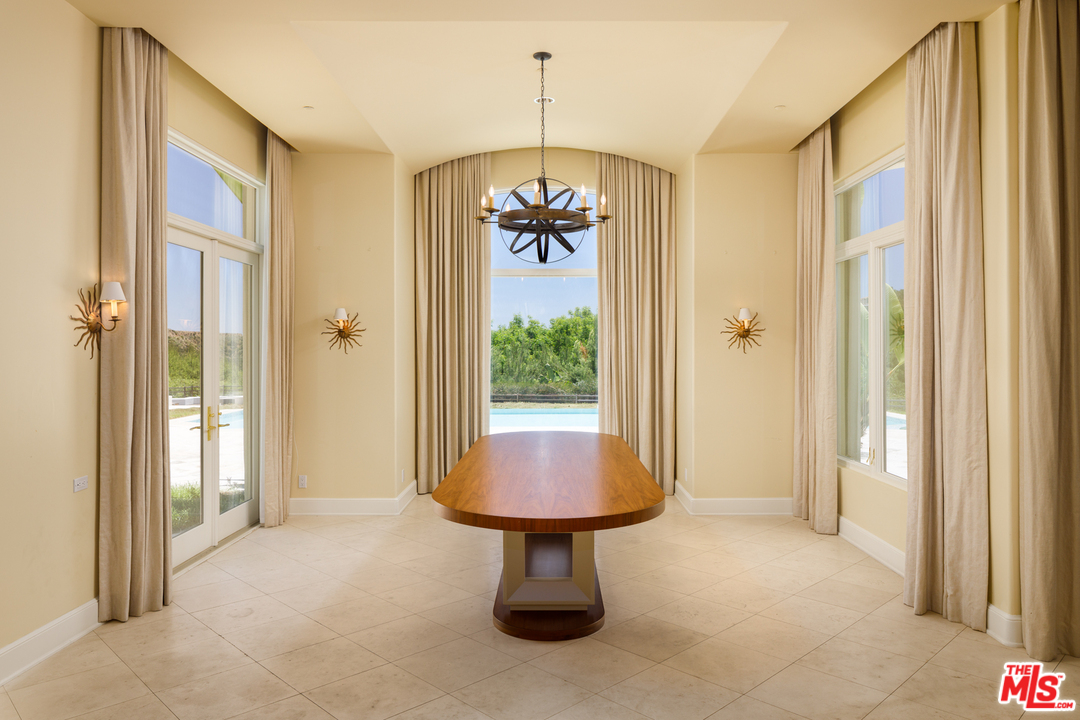 73 Beverly Park Lane Beverly Hills, CA 90210 - Photo 16 of 24 a view of a hallway with a chandelier