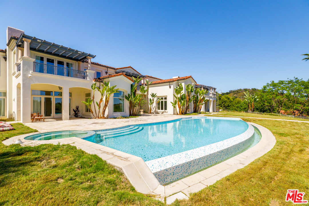 73 Beverly Park Lane Beverly Hills, CA 90210 - Photo 23 of 24 a view of a house with swimming pool and a yard