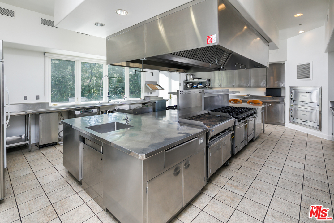 73 Beverly Park Lane Beverly Hills, CA 90210 - Photo 10 of 24 a kitchen with stainless steel appliances granite countertop a sink and a stove