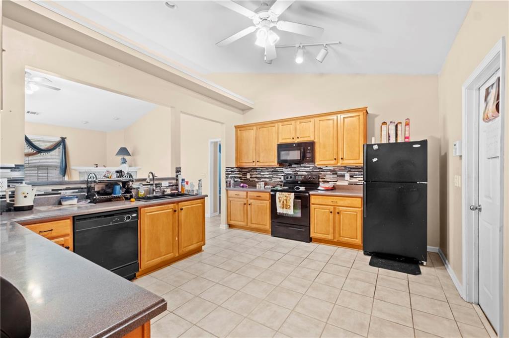 Undisclosed Address Atlanta, GA 30331 - Photo 5 of 25 a kitchen with stainless steel appliances granite countertop a refrigerator a stove top oven a sink a dining table and chairs