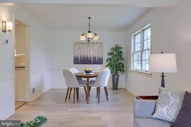 a dining room with furniture a chandelier and wooden floor